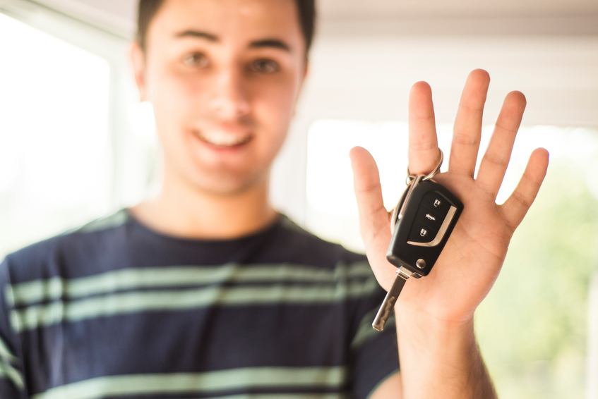 A young man holding car keys.