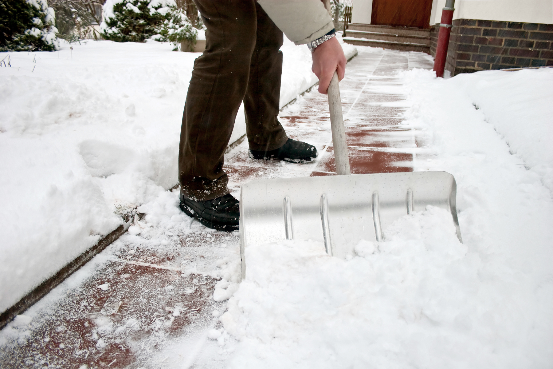 Man shoveling snow at a footpath